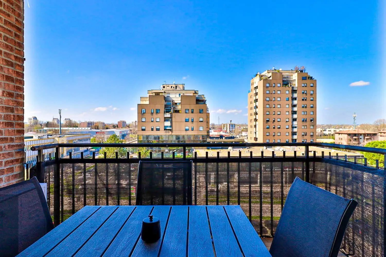 Balcone attrezzato con tavolo, sedie e vista sulla città