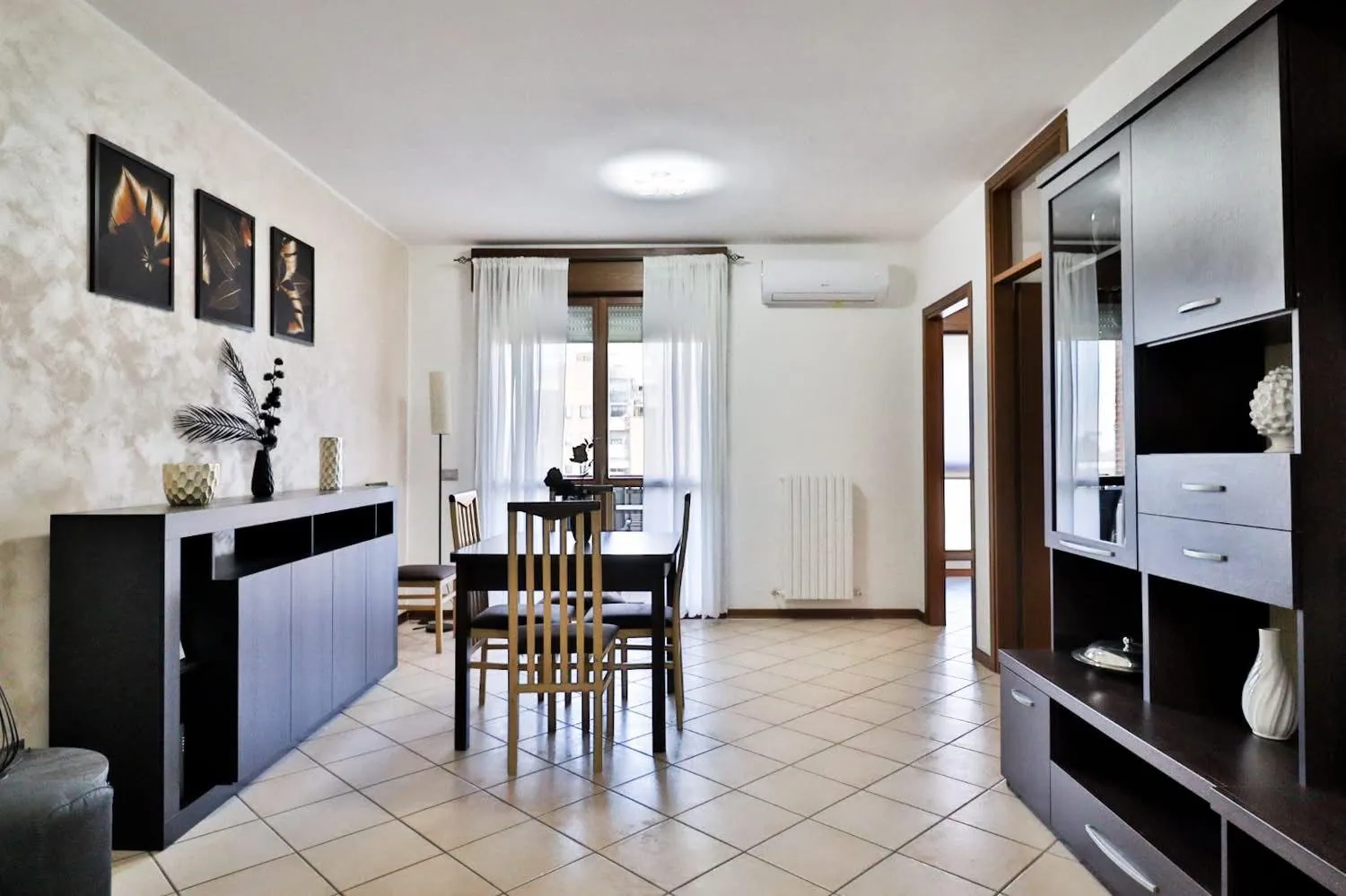 Soggiorno luminoso con zona pranzo e porta finestra sul balcone